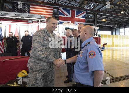 Us Air Force Colonel Christopher Bromen, 423Rd Air Base Group Commander, schüttelt Hände mit Feuerwehrmänner vom 423Rd Bauingenieur Squadron nach dem 2018 Brandschutz Woche Verkündigung Unterzeichnung an RAF ALCONBURY, England am Okt. 5, 2018. Brandschutz Woche findet jährlich im Oktober in einer Bemühung, die Gemeinschaft über den Brandschutz und Vorbeugung zu informieren. Stockfoto