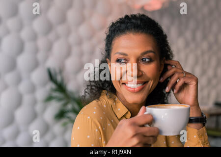 Portrait von schöne dunkelhaarige curly Frau ihre Tasse Kaffee Stockfoto