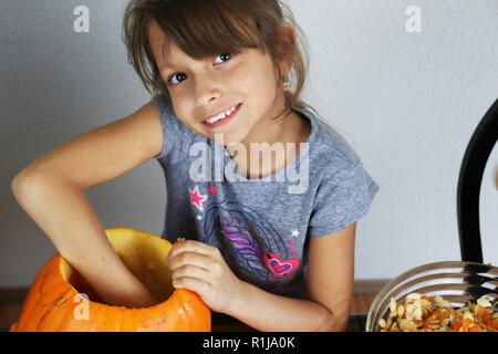 Kind Carving eine orange Kürbis während der Halloween Jahreszeit Stockfoto