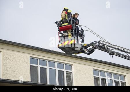 Us-Armee die zivilen Feuerwehrmänner von U.S. Army Garrison (USAG) Ansbach Evakuierung und Rettung Verfahren auf Bataillon und Feuerwehr Hauptquartier bei Storck Baracken in Illesheim, Deutschland, Okt. 10, 2018 demonstrieren. Die Demonstration ist Teil der jährlichen Einhaltung der Garnison von Brandschutz Woche. Stockfoto