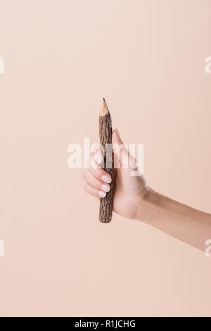 Schuß von Frau mit Bleistift von Stick isoliert auf beige, 7/8 Stockfoto