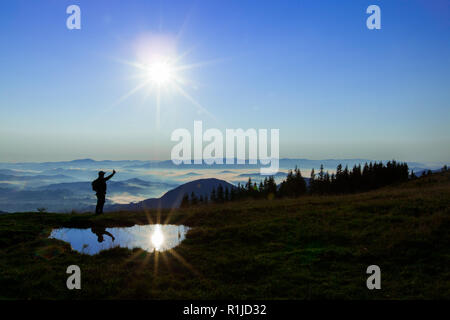 Wolken über den Bergen zusammen mit dem blauen Himmel auf diesem Hintergrund eine Abbildung eines Mannes und nur Sonnenschein und die Reflexion der Sonne in einer Pu Stockfoto