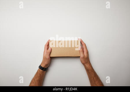 Zugeschnittenes Bild der Mann hält Lieferung Food Box auf weiße Oberfläche Stockfoto