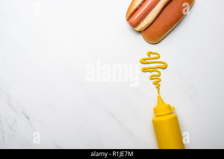 Blick von oben auf die leckeren Hot Dog mit Senf auf weißem Marmor Oberfläche Stockfoto