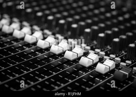 Geringe Aussicht auf Fader auf eine professionelle Audio Sound Mixing Console im Music Festival, schwarze und weiße Fader Stockfoto