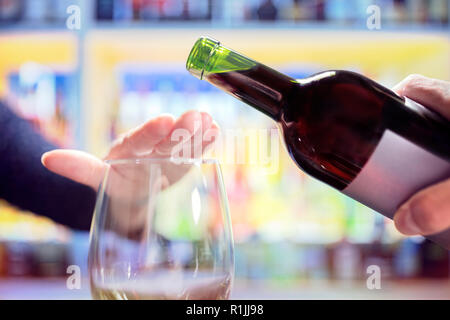 Womans hand Ablehnung mehr Alkohol aus Wein Flasche in bar Stockfoto