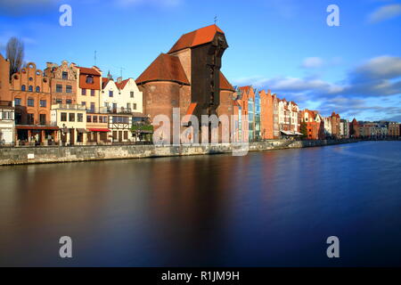 Panorama der Danziger Altstadt, Fluss, Ufer, schöne Architektur, mittelalterlicher Kran, Skyline, blauer Himmel mit einigen Wolken, langen Belichtungszeit. Stockfoto