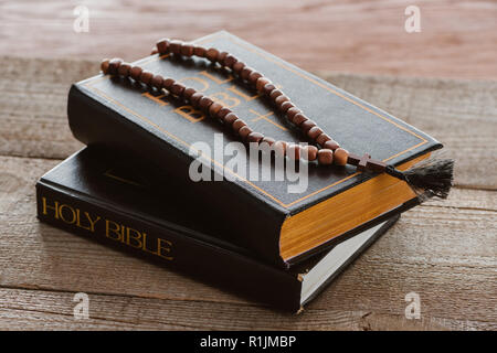 Nahaufnahme der gestapelten Bibel Bücher mit Perlen auf Holz- Oberfläche Stockfoto