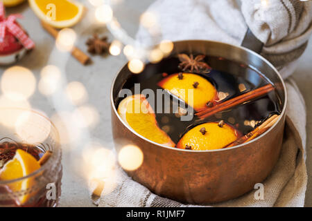 Traditionelle Winter und Weihnachten trinken Glühwein, heiße Getränke mit Orangen und Gewürze in Kupfer pot Stockfoto