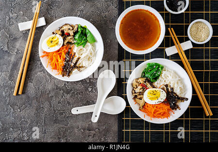 Ernährung vegetarische Schüssel Nudelsuppe von Shiitake Pilze, Karotte und gekochte Eier. Japanisches Essen. Ansicht von oben. Flach Stockfoto