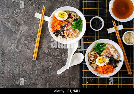 Ernährung vegetarische Schüssel Nudelsuppe von Shiitake Pilze, Karotte und gekochte Eier. Japanisches Essen. Ansicht von oben. Flach Stockfoto