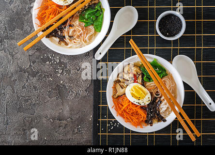 Ernährung vegetarische Schüssel Nudelsuppe von Shiitake Pilze, Karotte und gekochte Eier. Japanisches Essen. Ansicht von oben. Flach Stockfoto