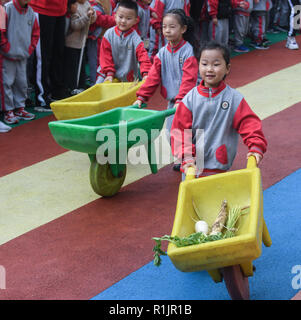 Changxing, der chinesischen Provinz Zhejiang. 13 Nov, 2018. Kinder vermitteln, Getreide und Gemüse während einer amüsanten Sport treffen in der Zentrale des Kindergartens in Changxing County, im Osten der chinesischen Provinz Zhejiang, Nov. 13, 2018. Credit: Xu Yu/Xinhua/Alamy leben Nachrichten Stockfoto