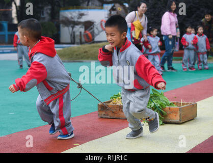 Changxing, der chinesischen Provinz Zhejiang. 13 Nov, 2018. Kinder vermitteln, Getreide und Gemüse während einer amüsanten Sport treffen in der Zentrale des Kindergartens in Changxing County, im Osten der chinesischen Provinz Zhejiang, Nov. 13, 2018. Credit: Xu Yu/Xinhua/Alamy leben Nachrichten Stockfoto