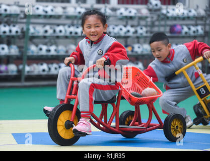 Changxing, der chinesischen Provinz Zhejiang. 13 Nov, 2018. Kinder vermitteln, Getreide und Gemüse während einer amüsanten Sport treffen in der Zentrale des Kindergartens in Changxing County, im Osten der chinesischen Provinz Zhejiang, Nov. 13, 2018. Credit: Xu Yu/Xinhua/Alamy leben Nachrichten Stockfoto