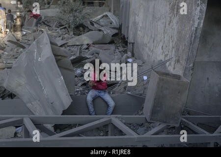 Gaza und die Palästinensischen Gebiete. 13 Nov, 2018. Eine palästinensische Mädchen prüft ein Schaden nach israelischen Luftangriffe. Credit: Mohammed Talatene/dpa/Alamy leben Nachrichten Stockfoto