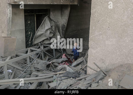 Gaza und die Palästinensischen Gebiete. 13 Nov, 2018. Ein palästinensisches Kind prüft ein Schaden von seinem Haus nach israelischen Luftangriffe. Credit: Mohammed Talatene/dpa/Alamy leben Nachrichten Stockfoto