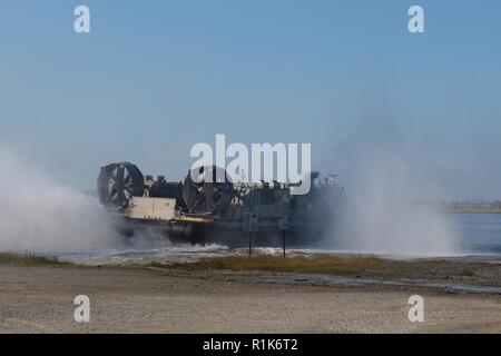 Ein U.S. Navy Landing Craft Air Cushion fliegt von Meile Hängematte Bay, Camp Lejeune in North Carolina, Okt. 5, 2018 Marines und Fahrzeuge während Typ Commander amphibischen Ausbildung zu USS New York (LPD-21). TCAT ermöglicht dem 24 Marine Expeditionary Unit, deren untergeordnete Einheiten und der U.S. Navy Iwo Jima Amphibious Ready Gruppe Schiff manövrieren und expeditionary Befehl und Kontrolle vor der Küste Trident Zeitpunkt 2018 Übung zu proben. Das Ziel der TCAT ist Einheit und individuelle Leistungsfähigkeit während amphibische Operationen zu erhöhen. Die Marines sind mit 2Nd Battalion, 2nd Marines, 24 Mari Stockfoto