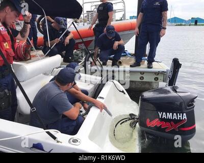 Coast Guard Besatzungsmitglieder an Bord 45-Fuß-Antwort Boat-Medium von Fort Myers Beach, Florida, entwässern ein 19-Fuß-Boot am Bahnhof Dienstag, Oktober 9, 2018. Das Boot wurde zum Bahnhof Fort Myers Beach abgeschleppt nach Besatzungsmitglieder zwei Nautiker und Ihren Hund von der Überschwemmung Boot gerettet. Stockfoto