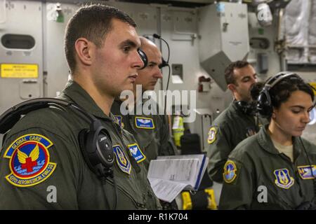 Us Air Force Senior Airman Timothy D. Kongo, Links, eine aeromedical evacuation Techniker mit dem 439Th Aeromedical Evacuation Squadron (AES), 1. Lt N. Bogdan Suciu, zweiter von links, ein Flug Krankenschwester mit der 439th AES; Tech. Sgt. Rocco L. Morello, zweiter von rechts, ein aeromedical evacuation Techniker mit dem 514th AES, 514Th Air Mobility Wing, und Senior Airman Stephanie Lezcano, einem aeromedical evacuation Techniker mit dem 45Th AES zum Abhören der Schulungsplan für die gemeinsame Ausbildung Mission mit dem 514th AES, 45th AES, und der 439th AES Friseure, Hawaii 6 Okt., 2018. Die 514Th Stockfoto