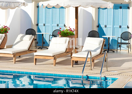 Liegen und Sonnenschirme am Pool in einem griechischen Resort Stockfoto