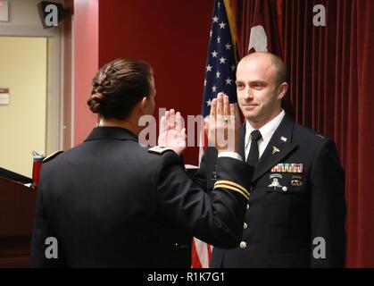 1. Lt Tschad Boone, eine dienststellenübergreifende Arzt Assistant Programm Student an Evans Armee Community Hospital, Fort Carson, Colorado, rezitiert die Eid der Kommission Okt. 5, 2018, während des IPAP Abschlussfeier. Kommilitonen, 1. Lt. Ellen Broz, verwaltet den Eid. Boone beauftragt als Offizier nach dem Abschluss des Programms. Boone wird als Arzt Assistent mit dem ersten Bataillon, 10 Special Forces Group (Airborne), in Stuttgart, Deutschland. Stockfoto
