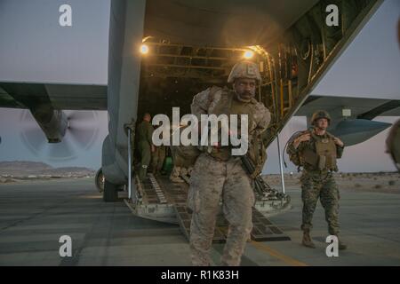 Us-Marines mit 1St Bataillon, 3. Marine Regiment, 3rd Marine Division, Offload von einer KC-130 Hercules-transportflugzeuge während Angriff unterstützen Taktiken 4, als Teil der Waffen und Taktiken Tauchlehrer Kurs 1-19 an strategischen Expeditionary Landeplatz, Marine Corps Air-Ground Combat Center Twentynine Palms, Calif., Okt. 9, 2018. WTI, sieben Woche Schulungsveranstaltung bewirtet durch Marine Aviation Waffen und Taktiken Squadron 1, betont die operative Integration der sechs Funktionen des Marine Corps Luftfahrt, bei der Unterstützung einer Marine Air-Task Force. In diesem Jahr, Marinesoldaten und Matrosen mit dem besonderen Zweck Ma Stockfoto