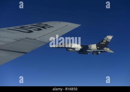 Ein US Air Force F-16C Fighting Falcon, die dem zugeordnet 18 Aggressor Squadron (AGR) fliegt neben dem Flügel einer KC-135 Stratotanker, die 168 Air Refuelling Squadron in der Gemeinsamen Pacific Alaska Range komplexe Okt. 8, 2018, während der roten Fahne - Alaska 19-1 zugewiesen. 18 AGR spielt die Rolle der gegnerischen Streitmacht im RF-A, Schulungen für andere Einheiten an der Übung teilnehmen. Stockfoto