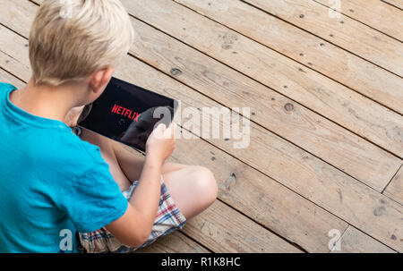 Junge beobachten Netflix auf seinem ipad Stockfoto