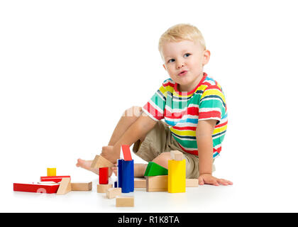 Kind Junge spielt Würfel sitzen. Auf einem weißen Hintergrund. Stockfoto