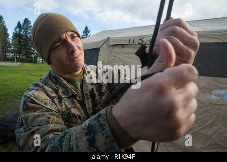 Us Marine Corps Cpl. Devin Edmondson mit Sitz Regiment, 2. Marine Logistik Gruppe Vorwärts, Krawatten die Gurte von einem Tierheim zusammen während der Konstruktion des 2. MLG VORWÄRTS-Befehl Operation Center für Trident Punkt 18 in Norwegen, Oktober 7, 2018. Trident Punkt 18 ist ein Teil der geplanten Übung Serie Fähigkeit, die USA und die NATO-Verbündeten zur Zusammenarbeit militärische Operationen unter schwierigen Bedingungen zu verbessern. Stockfoto