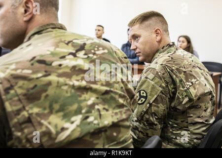 Maj. Wes Wingo von der 278th Armored Cavalry Regiment aus Tennessee hört Sie einen Lautsprecher während eines Besuchs von lokalen Studenten an der Yavoriv CTC Sim-Center, Okt. 10. Stockfoto