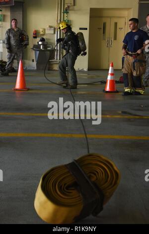 Us Air Force Colonel Jesse Friedel, 51th Fighter Wing stellvertretender Kommandeur, zieht in einem Feuerwehrschlauch während die Adler und Kommandeure versus Häuptlinge und Shirts Feuer versammeln am Osan Flughafen, der Republik Korea, Okt. 12, 2018. Die freundliche Konkurrenz zwischen höheren Beamten und Soldaten Führer Teil des Brandschutzes Woche war, statt 9 bis 13 Okt., und gab jedem eine Chance zu sehen, was die Brandbekämpfung durch gehen, wenn Ausbildung und Rettung von Personen bei Bränden. Stockfoto