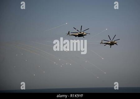 ARABIAN SEA - Zwei CH-53E Super Stallion Hubschrauber mit Marine Medium Tiltrotor Squadron 166 verstärkt, 13 Marine Expeditionary Unit (MEU), starten Sie es während einer Übung, 7. Oktober, 2018. Der Essex ist das Flaggschiff der Essex amphibische Gruppe und bereit, mit der begonnen 13. MEU, ist für die US-Fünften Flotte Bereich der Maßnahmen zur Unterstützung der Marine im Einsatz für die Stabilität und Sicherheit in der Region zu gewährleisten und verbindet das Mittelmeer und den Pazifischen Raum durch den westlichen Indischen Ozean und drei strategischen Punkten ersticken. Stockfoto