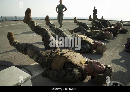 Arabischen Golf - US-Marines mit dem 13 Marine Expeditionary Unit (MEU), Flattern ausführen Tritt bei einem Martial Arts Instructor Kurs körperliches Training Event an Bord der Whidbey Island-Klasse dock Landung Schiff USS Rushmore (LSD 47), Okt. 11, 2018. Das Essex Amphibious Ready Gruppe und dem 13 MEU sind in die USA 5 Flotte Bereich der Maßnahmen zur Unterstützung der Marine im Einsatz für die Stabilität und Sicherheit in der Region zu gewährleisten und verbindet das Mittelmeer und den Pazifischen Raum durch den westlichen Indischen Ozean und drei strategischen Punkten ersticken. Stockfoto
