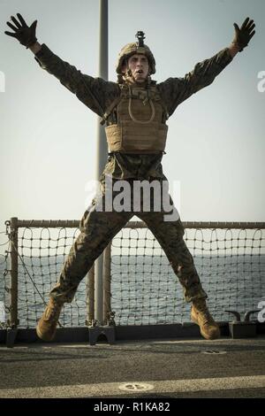 Arabischen Golf - US Marine 2 Leutnant Matthew Condara, ein platoon Commander mit Kilo Firma, Bataillon Landung Team 3/1, 13 Marine Expeditionary Unit (MEU), Sprünge in die Luft für einen Star springen Übung während eines Martial Arts Instructor Kurs körperliches Training Event an Bord der Whidbey Island-Klasse dock Landung Schiff USS Rushmore (LSD 47), Okt. 11, 2018. Das Essex Amphibious Ready Gruppe und dem 13 MEU sind in die USA 5 Flotte Bereich der Maßnahmen zur Unterstützung der Marine im Einsatz für die Stabilität und Sicherheit in der Region zu gewährleisten und verbindet das Mittelmeer und den Pazifischen Raum. Stockfoto
