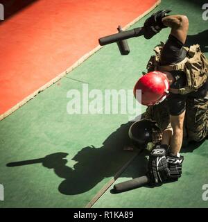 Arabischen Golf - US Marine Staff Sgt. Alexander Teegarden, ein platoon Sergeant mit Kilo Firma, Bataillon Landung Team 3/1, 13 Marine Expeditionary Unit (MEU), wirft eine Baton Cpl zu streiken. Harlan Ross, einer Maschine gunner mit Waffen, 13. MEU, während ein Martial Arts Instructor Kurs Höhepunkt an Bord der Whidbey Island-Klasse dock Landung Schiff USS Rushmore (LSD 47), Okt. 11, 2018. Das Essex Amphibious Ready Gruppe und dem 13 MEU sind in die USA 5 Flotte Bereich der Maßnahmen zur Unterstützung der Marine im Einsatz für die Stabilität und Sicherheit in der Region zu gewährleisten, Stockfoto