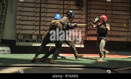 Arabischen Golf - US Marine Cpl. Joffre Proano, einem Maschinengewehr Truppführer mit Waffen Firma, Bataillon Landung Team (BLT) 3/1, 13 Marine Expeditionary Unit (MEU), packt Sgt. Trey Holman, ein Angriff Amphibienfahrzeug Abschnitt Führer, als Staff Sgt. Daniel Carter, ein platoon Sergeant, beide mit Kilo Unternehmen, BLT 3/1, 13 MEU, lenkt ihn in einem Martial Arts Instructor Kurs Höhepunkt an Bord der Whidbey Island-Klasse dock Landung Schiff USS Rushmore (LSD 47), Okt. 11, 2018. Das Essex Amphibious Ready Gruppe und dem 13 MEU sind in die USA 5 Flotte Bereich der Operationen in s bereitgestellt Stockfoto