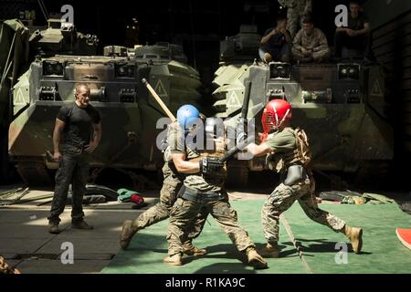 Arabischen Golf - US Marine Cpl. Nery Diffenderfer, einem Mörser Marine mit Waffen Firma, Bataillon Landung Team 3/1, 13 Marine Expeditionary Unit (MEU), Kämpfe aus zwei Angreifer bei einem Martial Arts Instructor Kurs Höhepunkt an Bord der Whidbey Island-Klasse dock Landung Schiff USS Rushmore (LSD 47), Okt. 11, 2018. Das Essex Amphibious Ready Gruppe und dem 13 MEU sind in die USA 5 Flotte Bereich der Maßnahmen zur Unterstützung der Marine im Einsatz für die Stabilität und Sicherheit in der Region zu gewährleisten und verbindet das Mittelmeer und den Pazifischen Raum durch den westlichen Indischen Oc Stockfoto
