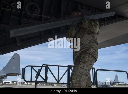 Eine flugzeugbesatzung Mitglied mit dem 15 Special Operations Squadron lasten Fracht auf einem MC-130H Combat Talon II Hurlburt Field, Florida, Okt. 12, 2018. Air Commandos transportiert liefert und eine mobile Küche, die von Fliegern wird zugeordnet, um die 823. RED HORSE Squadron nach der Hinterlassenschaft, die viele im Pfannenstiel ohne Strom und wesentlichen Leistungen Links betrieben werden. Stockfoto