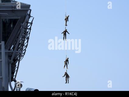 Philippinischen MEER (Okt. 2010) 11, 2018) - Marines, zugeordnet zu den 31 Marine Expeditionary Unit (MEU), von einem MH-60S Sea Hawk Hubschrauber auszusetzen, der "Insel der Ritter" Hubschrauber Meer Combat Squadron (HSC) 25 während eines speziellen Patrouille Einsetzen/Ausziehen (SPIE) Übung an Bord der Amphibisches Schiff USS Wasp (LHD1). Wasp, Flaggschiff der Wasp Amphibious Ready Group, mit 31 Marine Expeditionary Unit in Angriff genommen, ist die in der indopazifischen Region Interoperabilität mit Partnern zu verbessern und dienen als ready-Response Force für jede Art von Kontingenz. Stockfoto