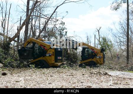 Staff Sgt. Alex Spano, elektrische Facharbeiter und Senior Airman Gonard Caudill, Heavy Equipment operator, sowohl aus der 202. Geben Sie der Camp Blanding, Fla., arbeiten zusammen mit Kompaktlader einen umgestürzten Baum auf Debi Straße im Bayou George Bereich von Panama City Okt. 14, 2018 zu löschen. Die GEBEN Sie auf Für ihr Know-how in der effizienten Route clearing genannt nach dem Hurrikan Michael durch kamen. Stockfoto