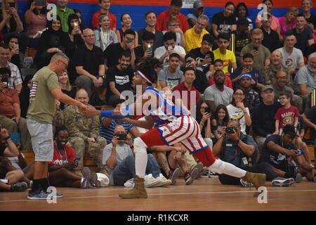 Kinder im Teenageralter aus Kuwait Schule und Familien von der Amerikanischen Botschaft in Kuwait verband Service Mitglieder an der Harlem Globetrotter Ausstellung Spiel am Lager Arfijan Okt. 12, 2018. Die Schülerinnen und Schüler an der Access-Jahra English Centre, Jahra, die vom US-Außenministerium finanziert. Die englische Zugang Microscholarship Programm bietet eine Grundlage für englische Sprachkenntnisse auf helle, wirtschaftlich benachteiligte Schüler, im Alter von 13 bis 20, die auch die Fähigkeit für zukünftige Austauschprogramme und Studium in den Vereinigten Staaten zu konkurrieren. "Die Kinder waren so glücklich, Sie nicht zu verlassen," sagte Dana Winn Stockfoto