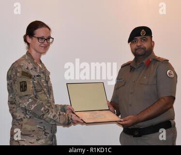 Oberst Dr. Raed R. Altajalli, assistant director of North Medizinische militärische Komplex stellt Oberstleutnant Dawn Coleman, mit dem 452Nd Combat Support Hospital, ein Zeichen der Wertschätzung für ihre Darstellung auf der chirurgischen Versorgung von Bekämpfung der Verluste im Norden Medizinische militärische Komplex, Kuwait am Okt. 4, 2018 bereitgestellt. Wenn nicht bereitgestellt, Coleman ist Associate Professor der Chirurgie und Pädiatrie sowie die Bekämpfung der übertragbaren Krankheiten Programm Direktor an der Universität von Michigan. Mitglieder der Area Support Group-Kuwait Truppe Medical Center und der 452Nd Combat Support Hospital Design erhöhen Stockfoto