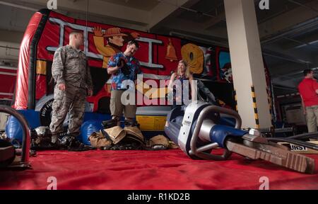 Us Air Force Staff Sgt. Benjamin Lalime, 18 Bauingenieur Squadron Feuerwehrmann, zeigt Teilnehmer der Feuerwache 1 Open House Rescue Equipment Oktober 6, 2018, auf Kadena Air Base, Japan. Die Open House war Gastgeber der 18. CES Bewußtsein über Brandschutz Brandschutz während der Woche zu erhöhen. Stockfoto