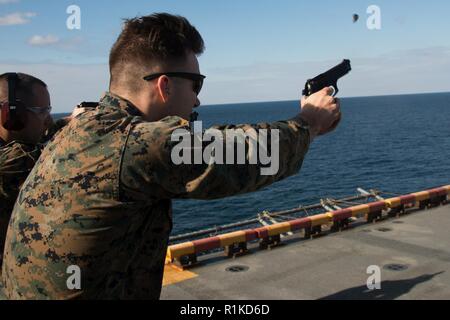 2. Lt. Maxwell Bennett, ein Kommunikation Strategie und Operations Officer mit 31 Marine Expeditionary Unit Brände eine M9A1 9-mm-Pistole während Pistole Qualifikation an Bord der Flight Deck der Amphibisches Schiff USS Wasp (LHD 1) im Ostchinesischen Meer, Okt. 15, 2018. Bennett, ein Eingeborener von Stilwell, Kansas, graduiert von William Jewell College im Mai 2016; er im November 2016 in Betrieb genommen. Marines durchlaufen jährlich Gewehr und Pistole Qualifikationen in ihre waffenfertigkeiten und Handhabung vertraut zu bleiben. Die 31. MEU, das Marine Corps' nur kontinuierlich vorwärts - bereitgestellt MEU, bietet Stockfoto