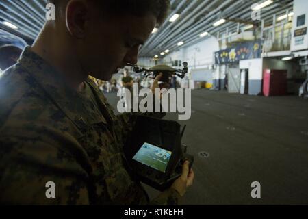 Lance Cpl. Michael Misbach, eine Intelligenz Spezialist mit Bataillon Landung Team, 2nd Battalion, 5th Marines, betreibt eine Instant Eye Mk-2 GEN 3 - 0 kleine unbemannte System während einer Inspektion an Bord der Amphibisches Schiff USS Wasp (LL 1), unterwegs in das Südchinesische Meer, Okt. 11, 2018. Marines mit der 31 Marine Expeditionary Unit Bodenkampf Element getestet Die Instant Eye betriebliche Nähe Aufklärung im Herbst Patrouille zu gewährleisten. Misbach, ein Eingeborener von New Haven, Connecticut, graduiert von Haven High School im Juni 2014. Er trug Januar 2017. Th Stockfoto