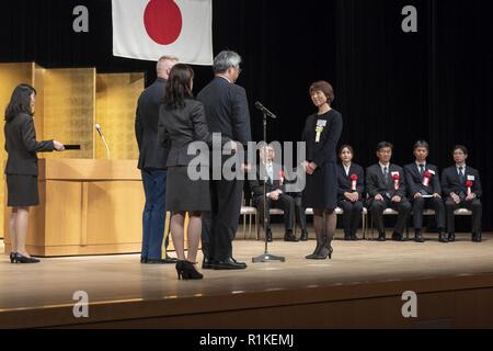 Rie Miyoshi, Stars und Stripes Tokio Management Analyst, bereitet ihre Auszeichnung für ihre Dienstjahre während der usfj Länge-von-Service Preisverleihung im Rathaus in Hamura Yutorogi Stadt, Japan, Oktober 10, 2018 zu erhalten. Die Veranstaltung feierte der Service von 233 Regierung von Japan Mitarbeiter, die als Teil der USFJ für 10, 20, 30 und 40 Jahre gearbeitet haben. Stockfoto