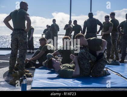 Philippinischen MEER (Okt. 2010) 15, 2018) Marines, angeschlossen an die 31 Marine Expeditionary Unit (MEU), Praxis submission Techniken auf dem Flugdeck der Amphibischen dock Landung Schiff USS Ashland (LSD 48). Ashland, Teil der Wasp amphibischen bereit, Gruppe, mit Eingeschifft 31 MEU, arbeitet in der indopazifischen Region Interoperabilität mit Partnern zu verbessern und dienen als ready-Response Force für jede Art von Kontingenz. Stockfoto