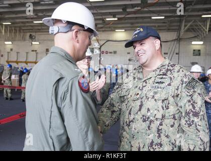 NEWPORT NEWS, Virginia (Okt. 2010) 11, 2018) Lt.Cmdr. Edward Chinone, von San Juan, Puerto Rico, schüttelt Hände mit Kapitän John J. Cummings, USS Gerald R. Ford's (CVN 78) kommandierenden Offizier, nach bittet um die Erlaubnis, an Land zu gehen. Stockfoto